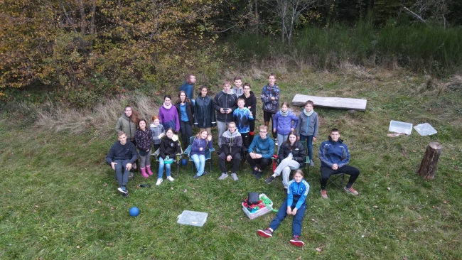 Dronenaufnahme von einer Gruppe auf einer Bergwiese